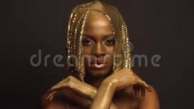 非洲裔美国女模特的超现实时尚肖像，金色光面头饰。创意概念，黑工作室